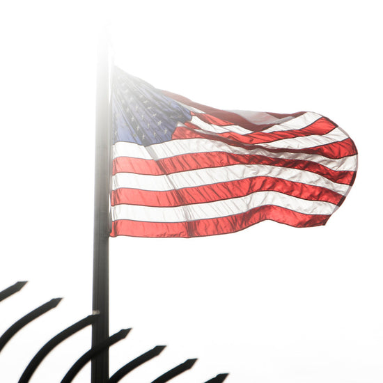 American flag waving on a pole with a blurred background