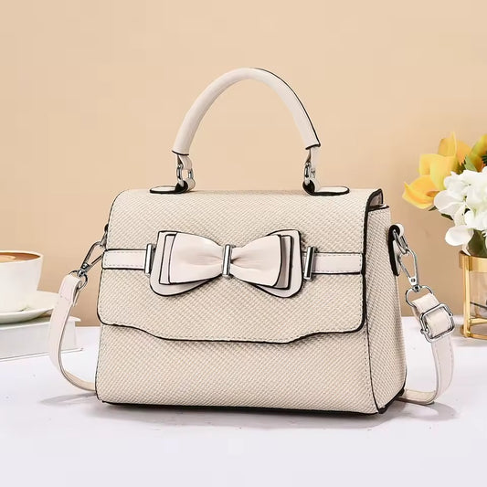 Beige handbag with a bow detail on a light background