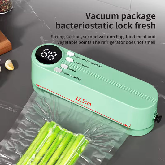 Green vacuum sealer with digital display on a kitchen counter, packaging food items.